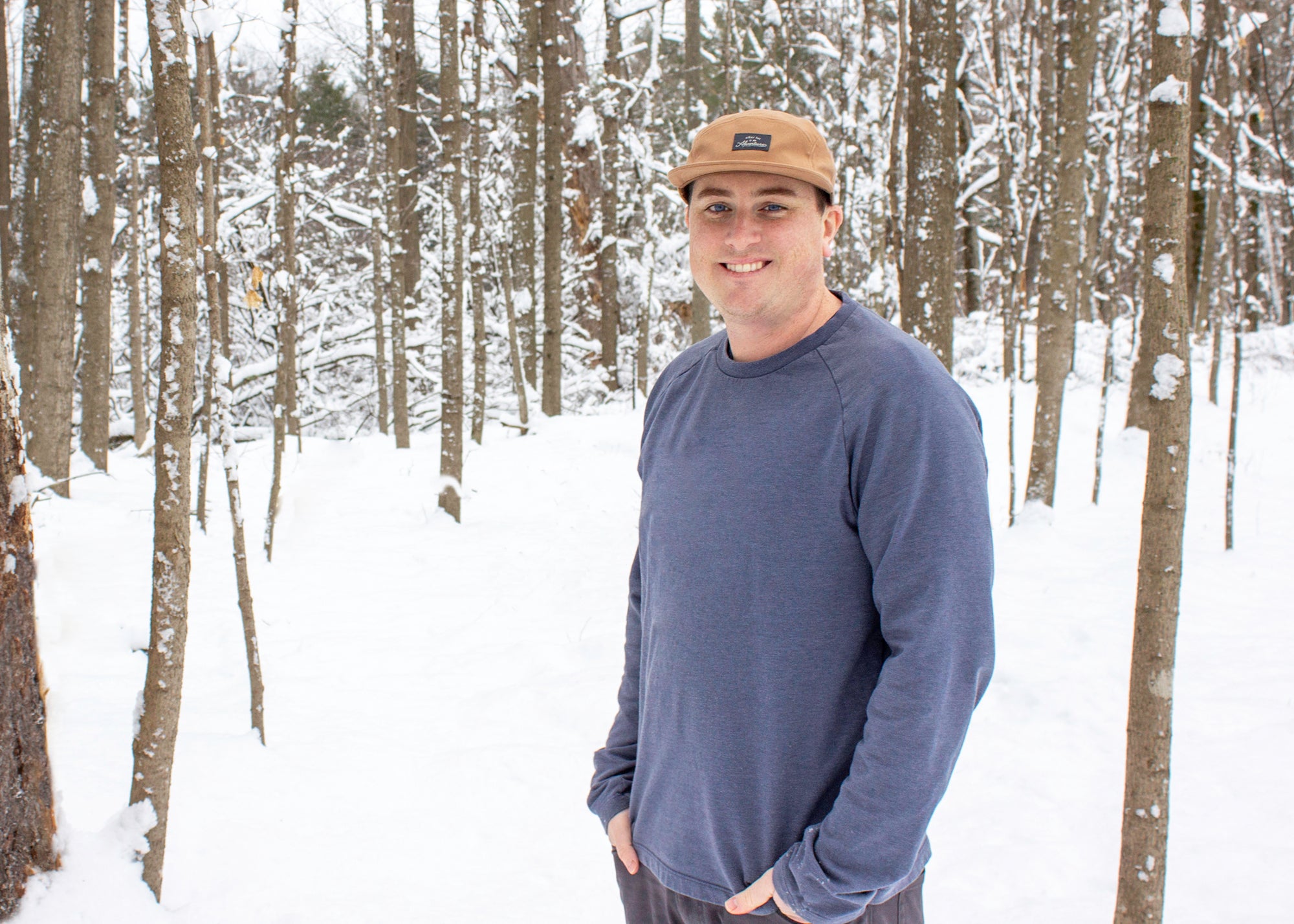 Kevin Sherry standing in a wooded area with snow on the ground