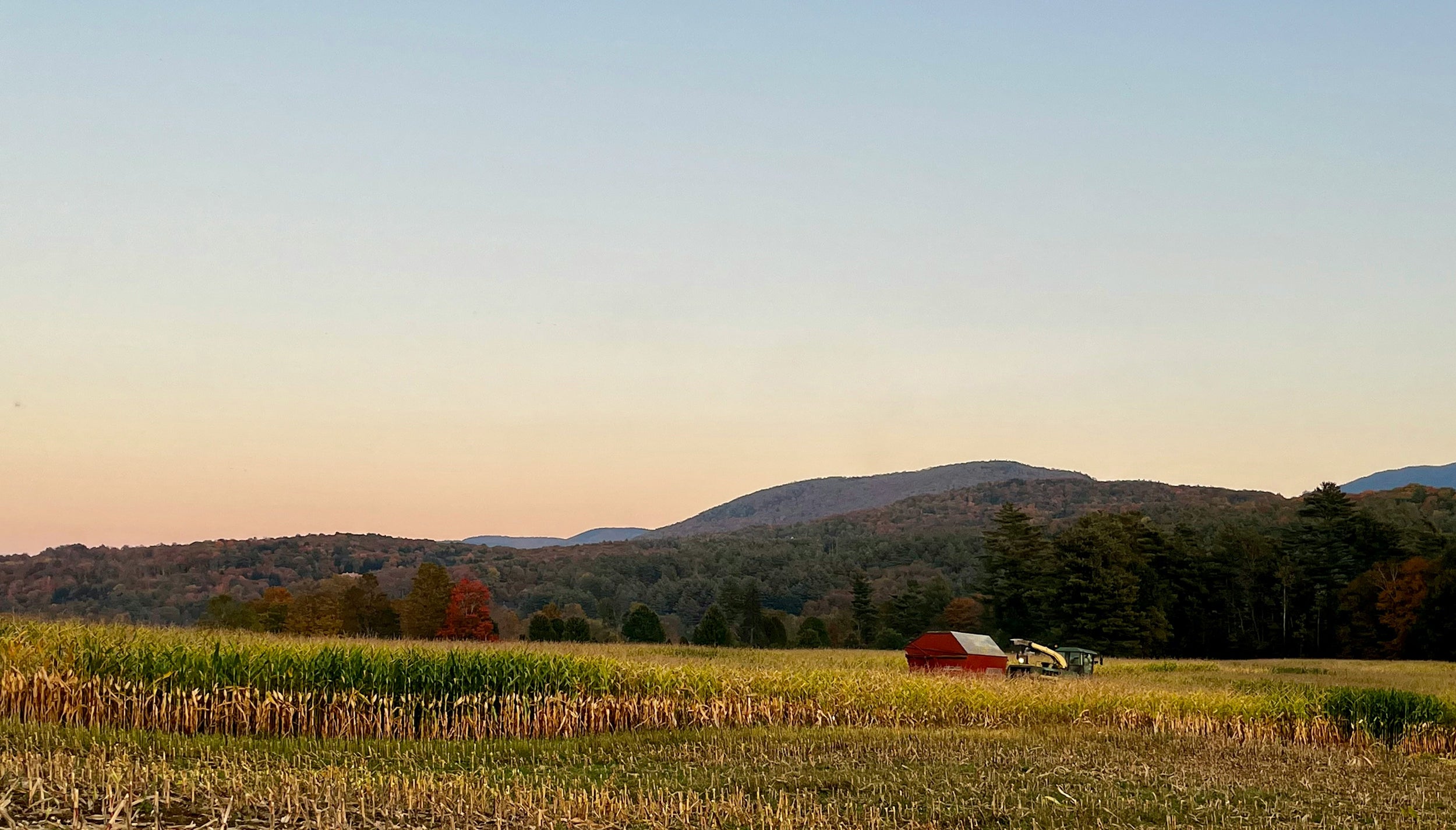 Red wagon in a field with Vermont mountains in the background